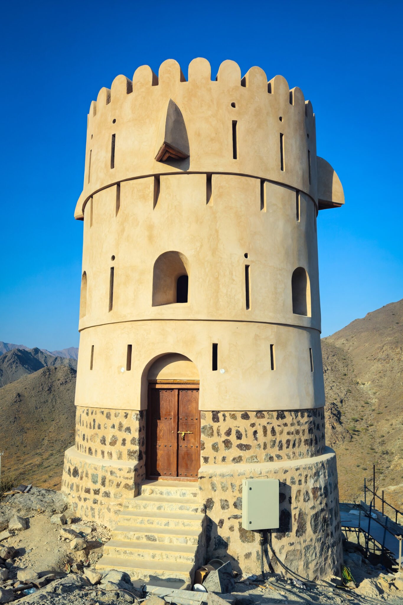Modern watchtower built in traditional Emirati style along the Al Suwaifa hiking trail, with the Hajar Mountains in the background.